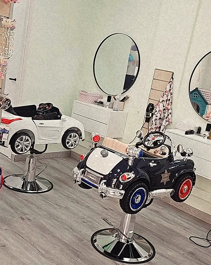 Zona de corte de ChiquiLook: dos sillones de peluquería con forma de coche, uno blanco y otro negro, delante de dos espejos redondos.